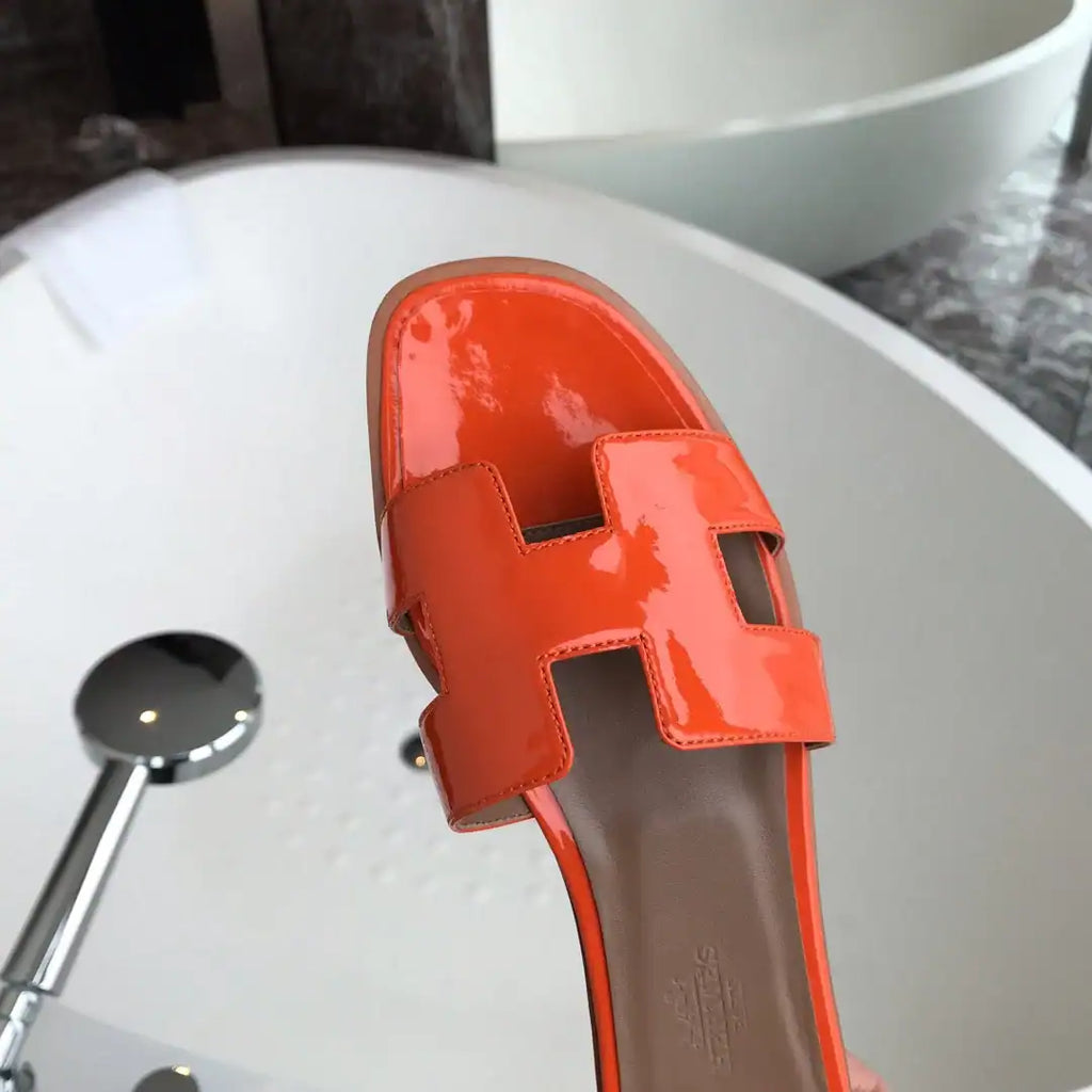 HERMES ORAN SLIDE SANDALS IN ORANGE PATENT CALFSKIN – HMSD085